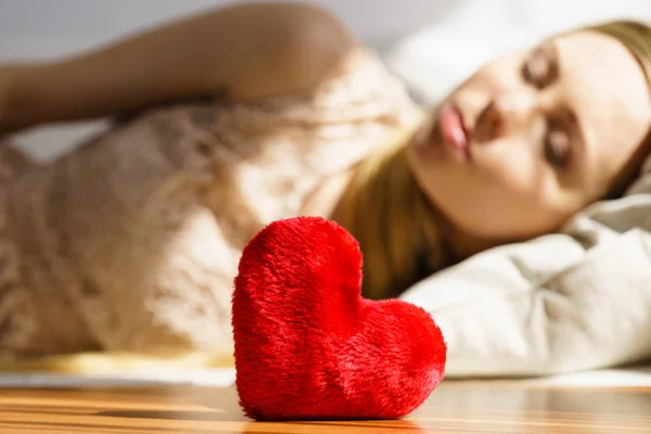 stock image Sad lonely woman being alone holding red heart shape. Female missing someone during valentines.