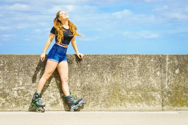 ローラースケートを屋外で身に着けている若い女性 ファッショナブルなフィット女の子持っています楽しいです日当たりの良い夏の日 — ストック写真