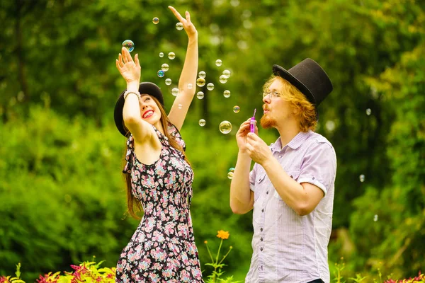 Happy Funny Hipster Couple Playing Together Blowing Soap Bubbles Outdoor — Stock Photo, Image