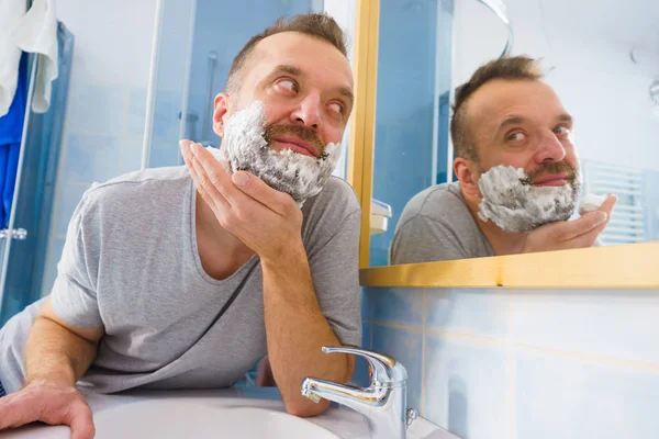 Hombre Aplicando Crema Espuma Afeitar Cara Pie Baño Mirando Espejo —  Fotos de Stock
