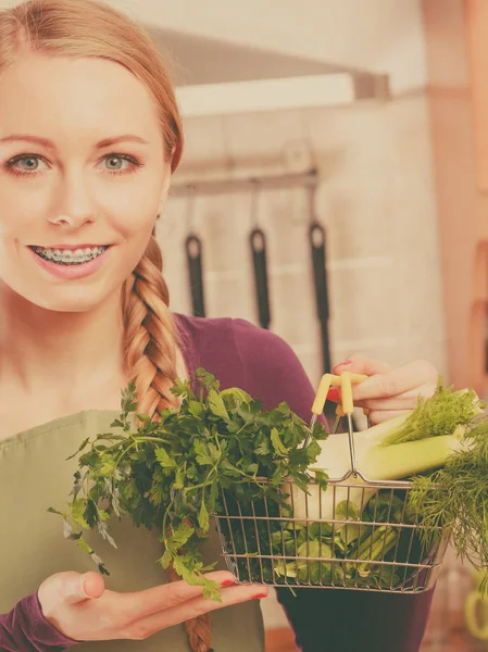 Жінка на кухні має овочі, що тримають кошик для покупок — стокове фото