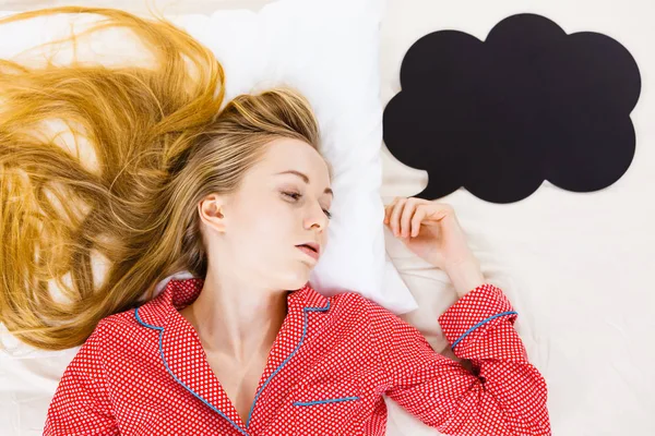 Young woman lying on bed wearing pajamas — Stock Photo, Image