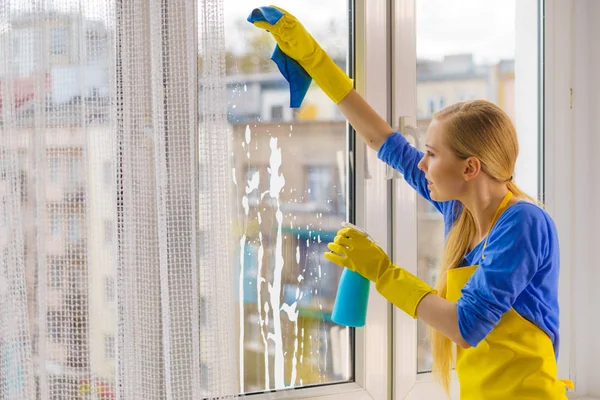 Kvinnans rengöringsfönster hemma — Stockfoto