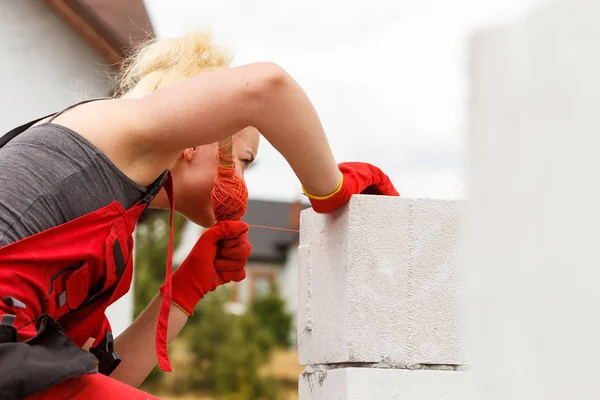 妇女在建筑工地上夷平空气砖 — 图库照片