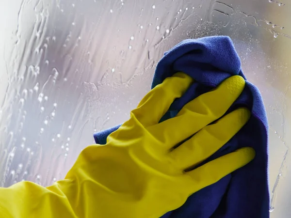 Gloved hand cleaning window rag and spray — Stock Photo, Image