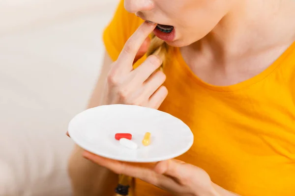 Mujer conmocionada teniendo pastillas en el plato —  Fotos de Stock