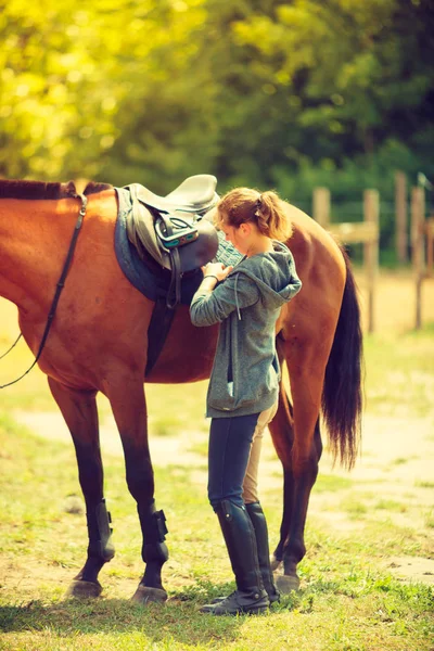 Vaquera conseguir caballo listo para montar en el campo — Foto de Stock