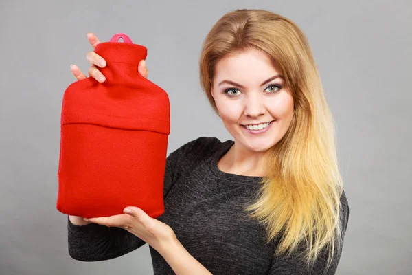 女人抱着温暖的红热水壶 — 图库照片