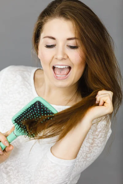 Mujer feliz cepillándose el pelo — Foto de Stock