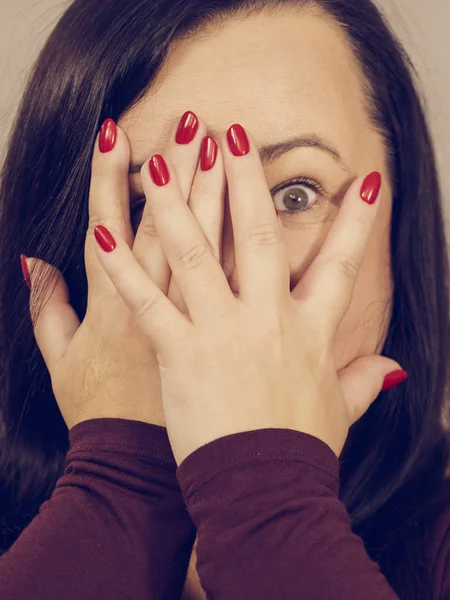 Mujer mirando a través de sus manos —  Fotos de Stock