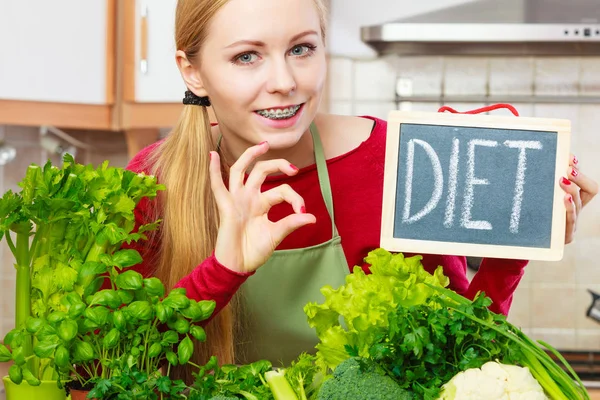 Femme dans la cuisine ayant des légumes de régime vert — Photo