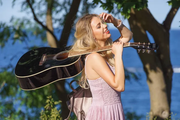 Mulher tocando guitarra acústica no parque — Fotografia de Stock