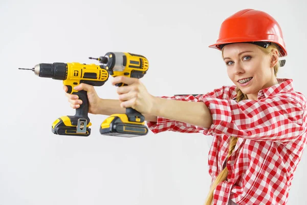 Donna che indossa il casco utilizzando trapano — Foto Stock