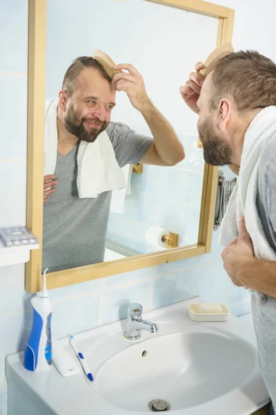 Homme utilisant peigne dans la salle de bain — Photo