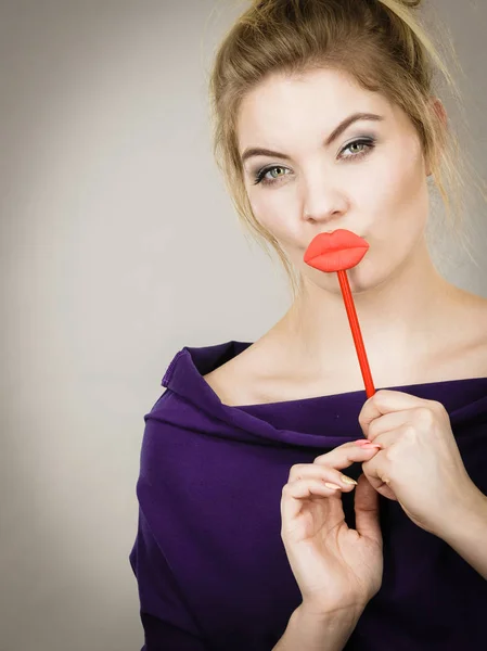 Büyük kırmızı dudaklar sopa üzerinde tutan komik kadın — Stok fotoğraf