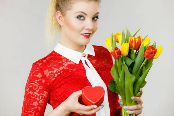 Vrouw bedrijf tulpen en cadeau — Stockfoto