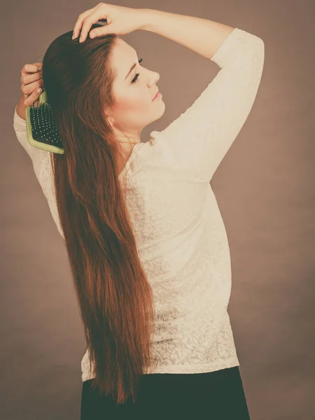 Mulher feliz escovando seu cabelo — Fotografia de Stock