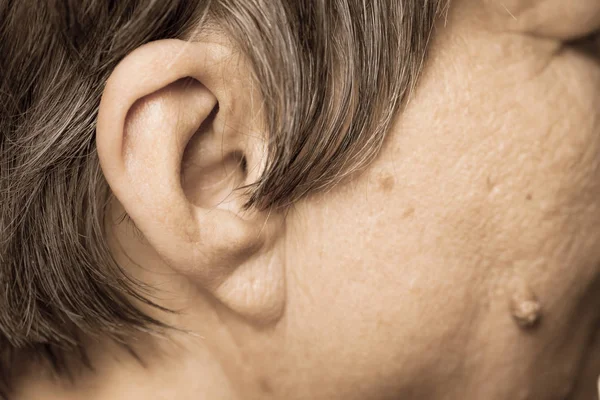 Elderly pensioner female, ear and cheek closeup. — Stock Photo, Image