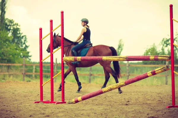 Jockey gadis muda melakukan lompat kuda melalui rintangan — Stok Foto