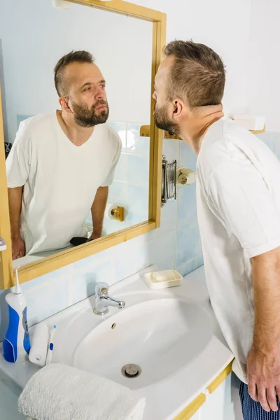 Hombre mirándose en el espejo — Foto de Stock