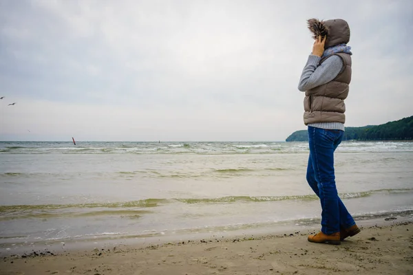 Frau spaziert am Strand, herbstlicher kalter Tag — Stockfoto