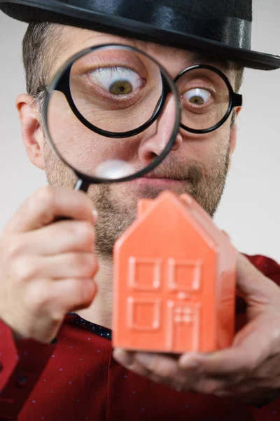 Man magnifying red house — Stock Photo, Image