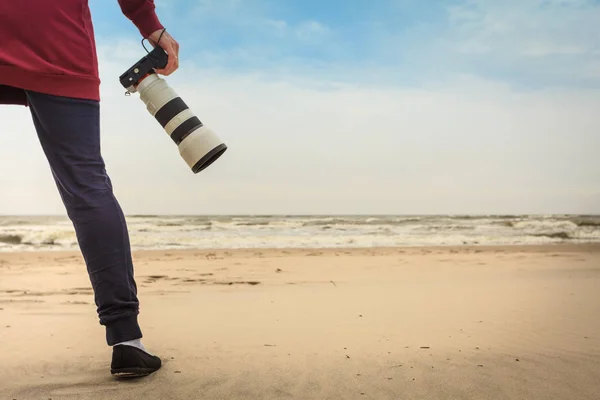 Žena kráčející po pláži s kamerou — Stock fotografie