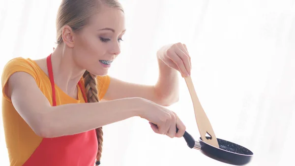 Woman holding cooking pan and spatula — Stock Photo, Image