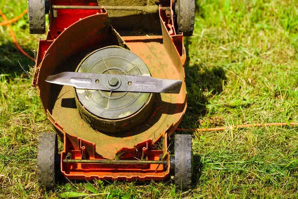 Broken old lawnmower in backyard grass