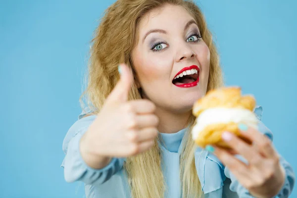 Funny woman holds cream puff cake — Stock Photo, Image