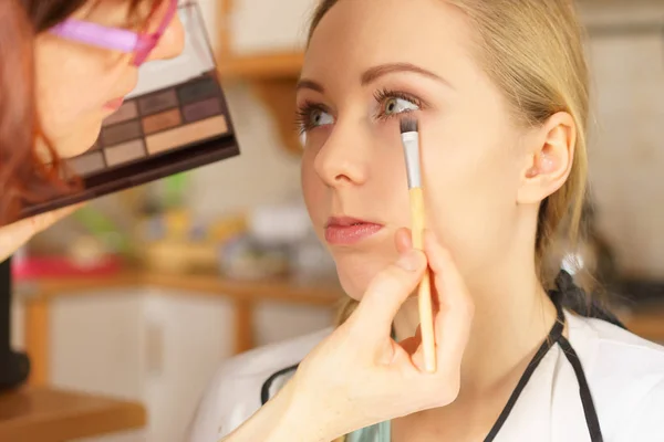 Vrouw krijgt make-up gedaan door kunstenaar — Stockfoto