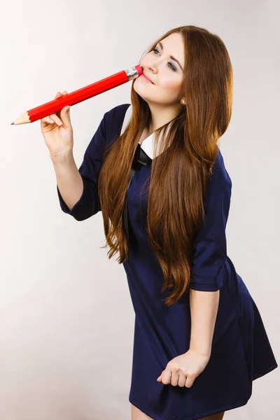 Estudiante chica buscando elegante mujer sosteniendo lápiz grande — Foto de Stock
