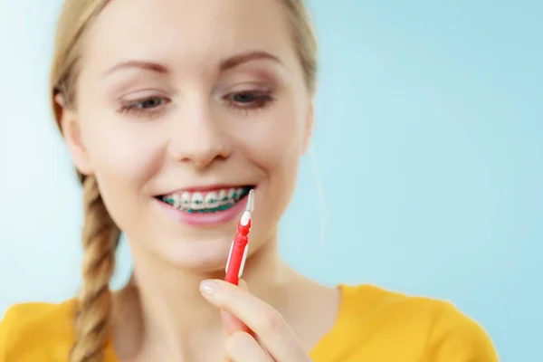 Mujer con aparatos ortopédicos usando cepillo interdental — Foto de Stock