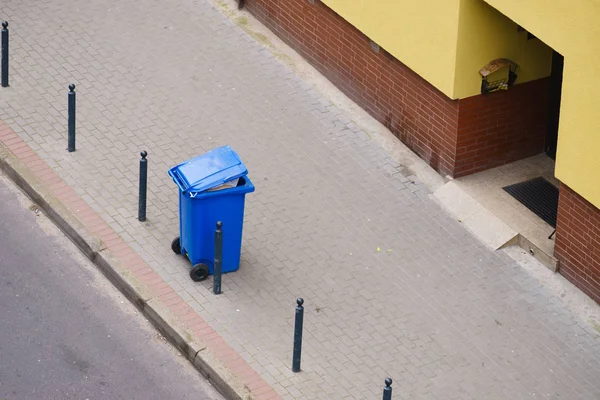 Blå papperskorgen på gatan trottoaren — Stockfoto