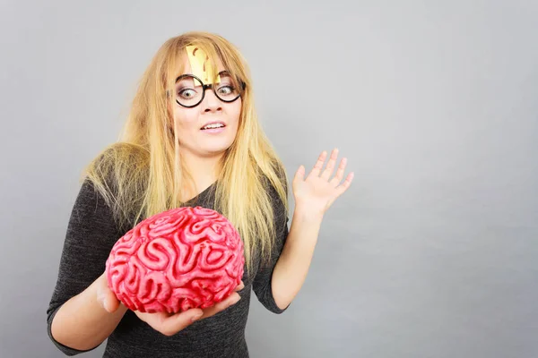 Mujer extraña sosteniendo el cerebro teniendo idea — Foto de Stock