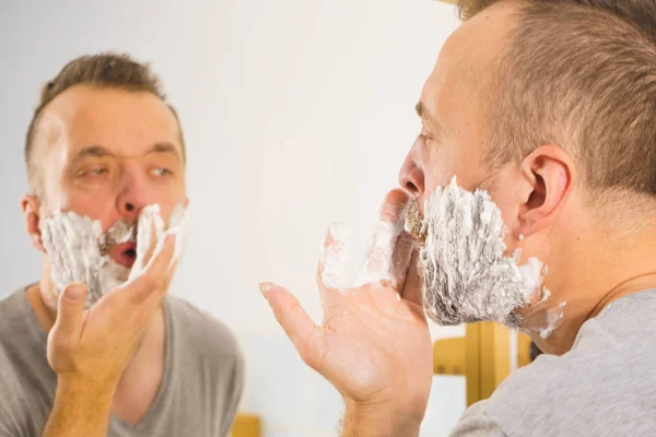 Tipo afeitándose la barba en el baño — Foto de Stock