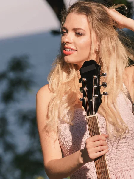 Vrouw speelt akoestische gitaar in het park — Stockfoto