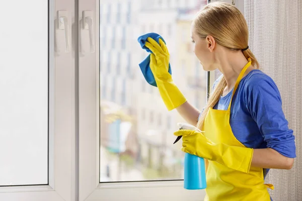 Mujer ventana de limpieza en casa —  Fotos de Stock