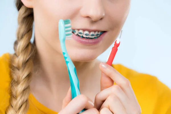 Mulher sorrindo dentes de limpeza com aparelho — Fotografia de Stock