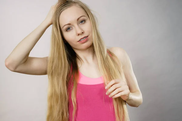 Jovem mulher tocando seu cabelo longo — Fotografia de Stock