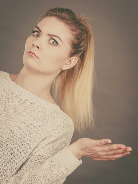 Verwirrte junge blonde Frau gestikuliert mit Händen — Stockfoto