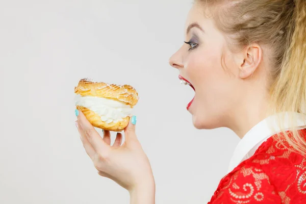 Funny woman holds cream puff cake — Stock Photo, Image