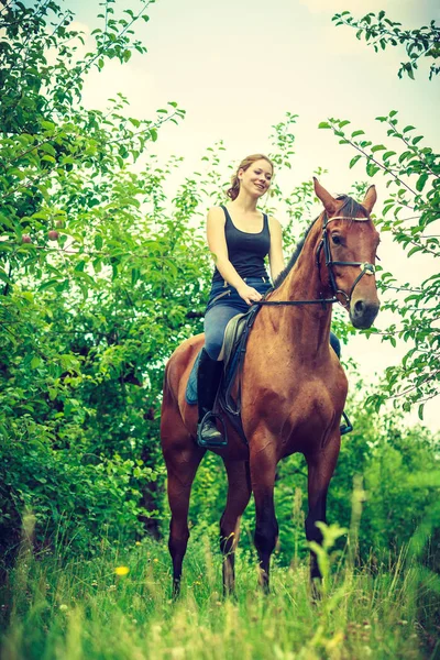 Jonge vrouw zitten op een paard — Stockfoto