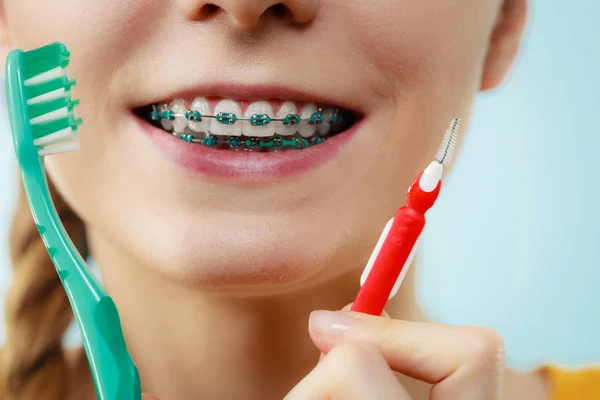 Menina com aparelho de dentes usando escova interdental e tradicional — Fotografia de Stock