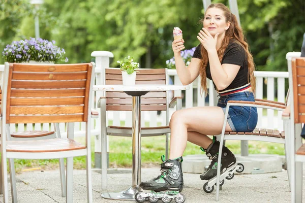 ローラー スケートの女性がアイスクリームを食べる — ストック写真