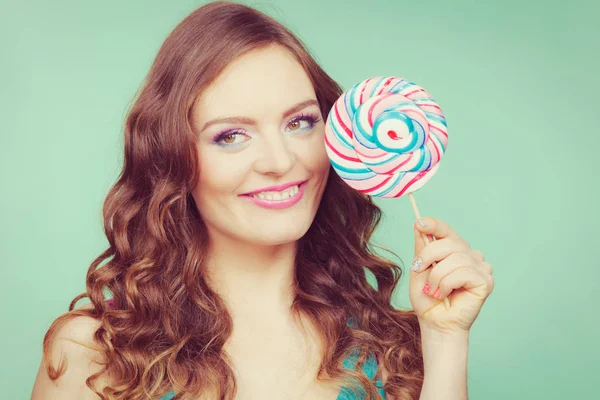 Smiling girl with lollipop candy on teal — Stock Photo, Image