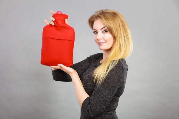 Happy woman holds hot water bottle — Stock Photo, Image