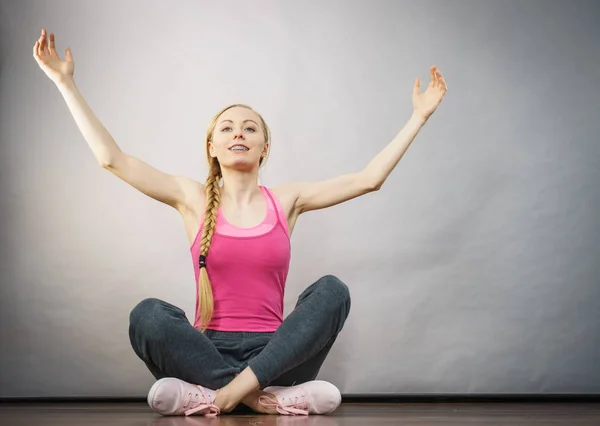 Vrouw in sportkleding zittend op grond — Stockfoto