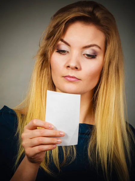 Femme sérieusement inquiète regardant un morceau de papier — Photo