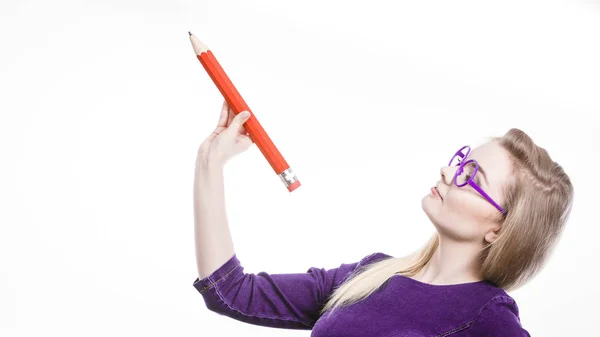 Femme souriante tient un gros crayon dans la main — Photo